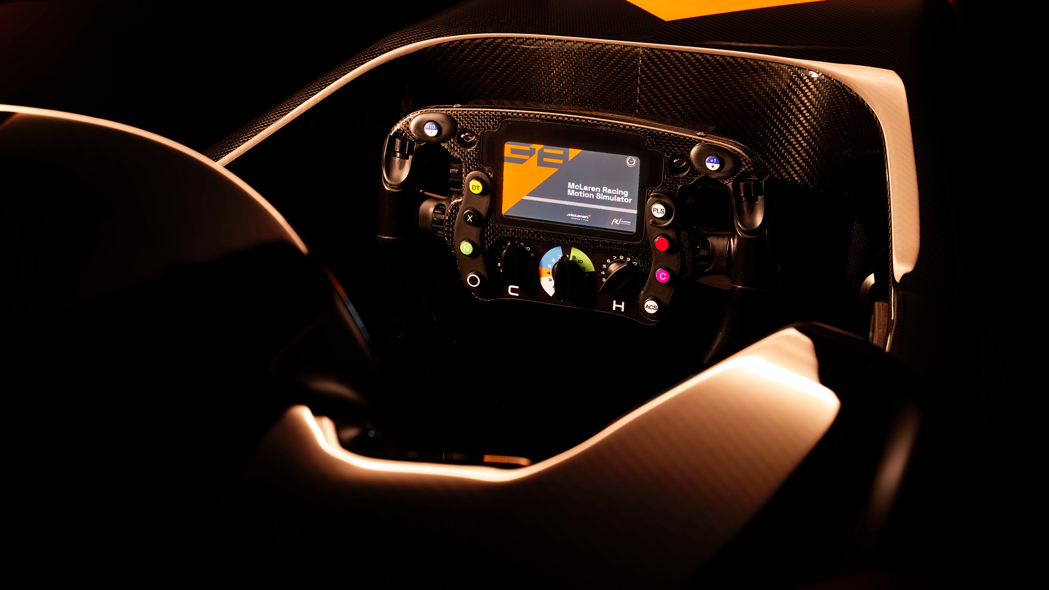 Ein McLaren Racing Simulator von Racing Unleashed mit beleuchtetem Lenkrad und Display.