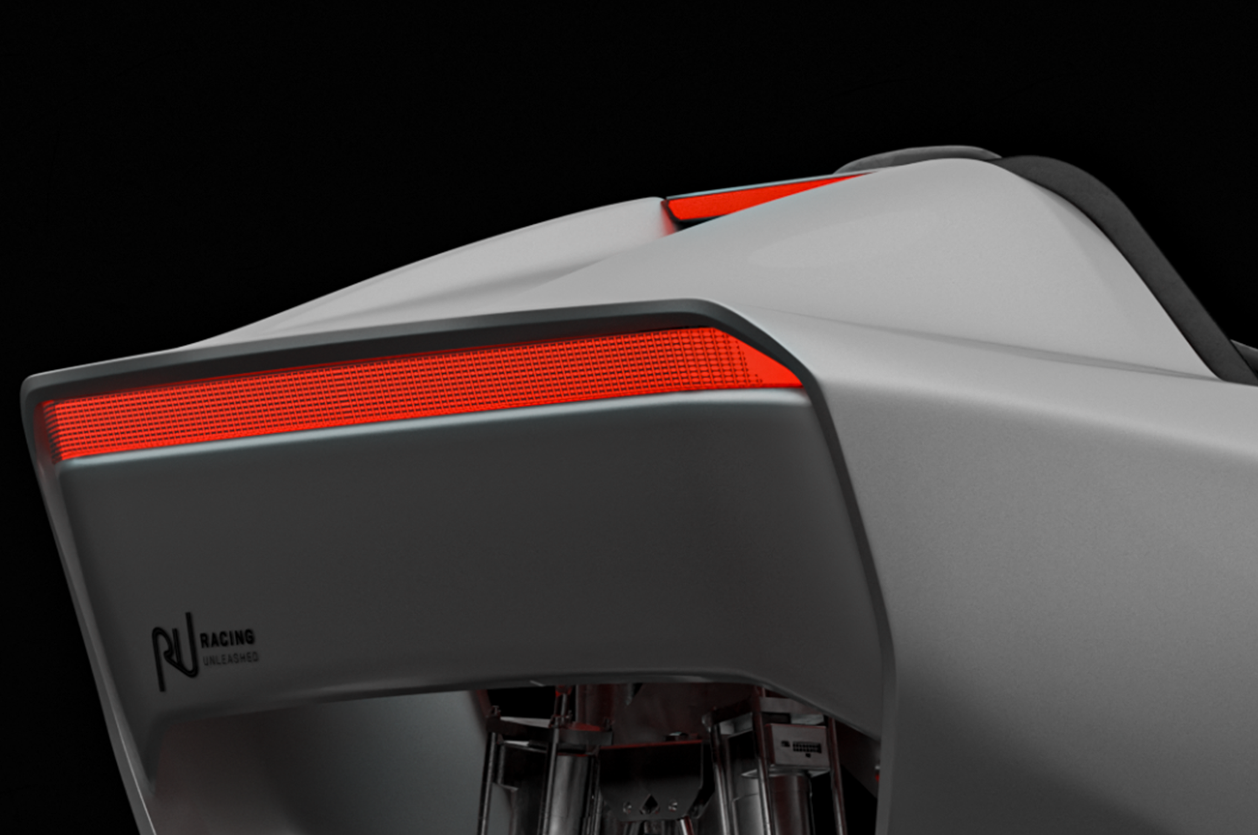 Grauer Rennsimulator mit rotem Licht und Racing Unleashed Logo auf schwarzem Hintergrund.